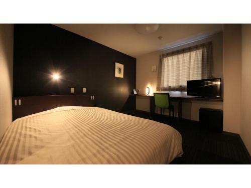 a bedroom with a bed and a desk and a window at HOTEL COONEL INN - Vacation STAY 33521v in Susono