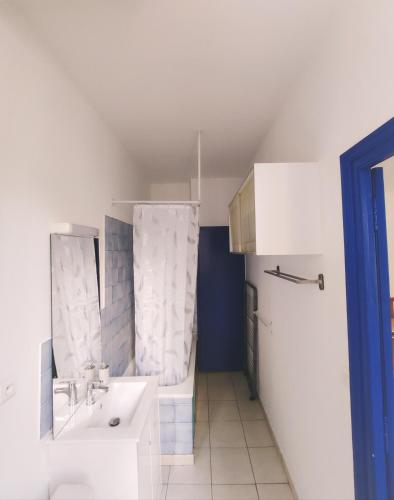 une salle de bain blanche avec un lavabo et un miroir dans l'établissement Appartement Cosy en centre centre-ville . . ., à Nîmes