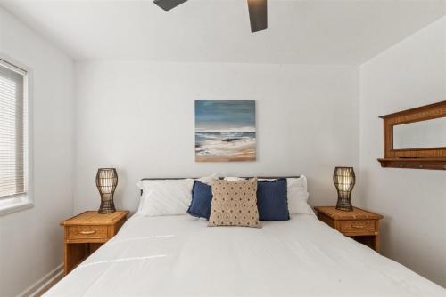 a bedroom with a white bed with two night stands at 104-unit 4 in San Diego