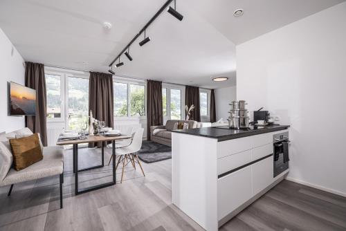 a kitchen and living room with a counter and a table at Max Studios & Apartments - Zillertal in Schlitters