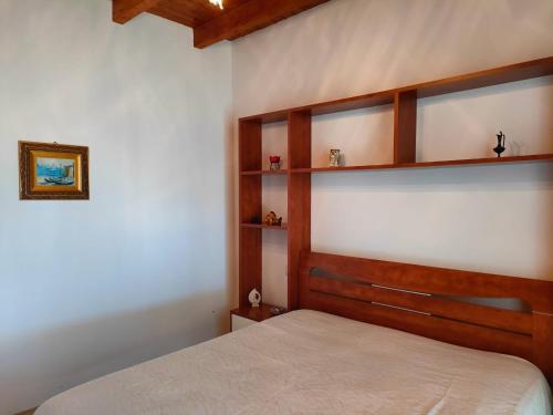 - une chambre avec un lit et des étagères en bois dans l'établissement Casa del Pescatore, à Trappeto