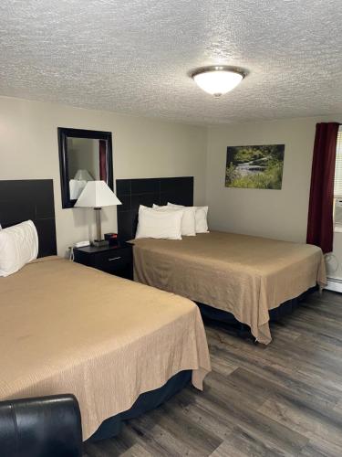 una habitación de hotel con 2 camas y una lámpara en The New Lantern Motel, en Allegany