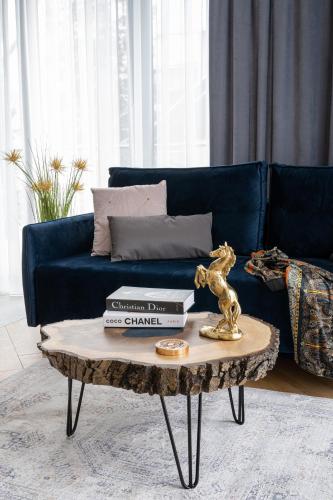 a living room with a blue couch and a coffee table at Wrota Chałubińskiego in Zakopane