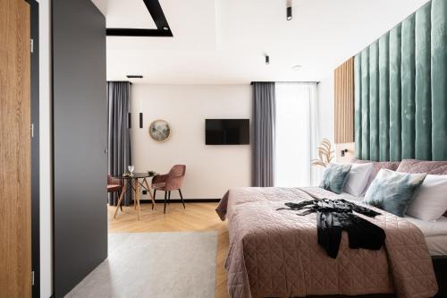 a hotel room with a bed and a table at Wrota Chałubińskiego in Zakopane