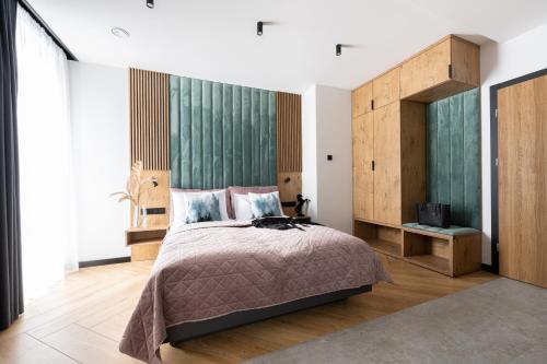 a bedroom with a large bed and a television at Wrota Chałubińskiego in Zakopane