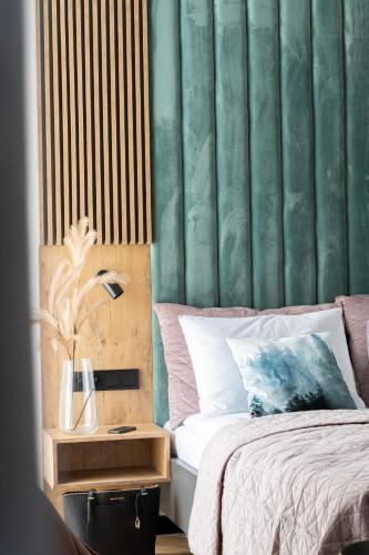 a bedroom with a bed and a green wall at Wrota Chałubińskiego in Zakopane