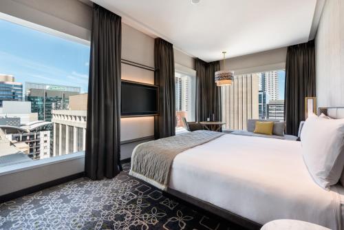 a bedroom with a large bed and a large window at InterContinental Perth City Centre by IHG in Perth