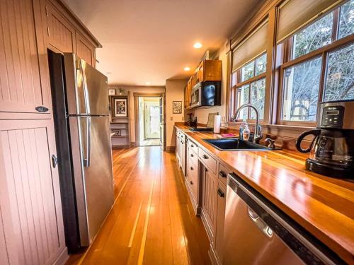 a kitchen with wooden floors and a stainless steel refrigerator at California Cottage in Jacksonville