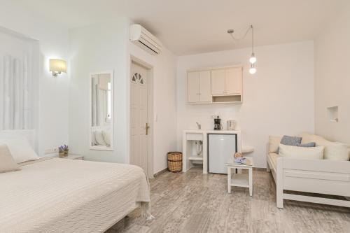 a white bedroom with a bed and a couch at Blue Sky Summer in Naxos Chora