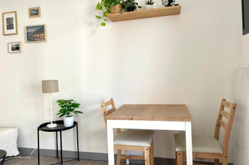 une table et des chaises dans une pièce avec un mur blanc dans l'établissement Le cosy de l'Ile Verte  #DD, à Grenoble