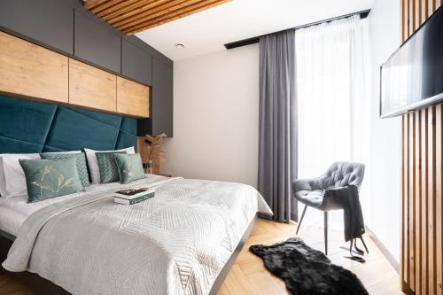 a bedroom with a large bed and a chair at Wrota Chałubińskiego in Zakopane