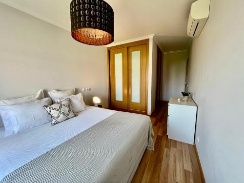 1 dormitorio con cama blanca y lámpara en My Place, en Portimão