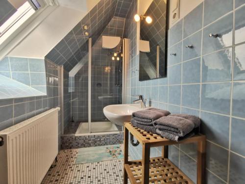 a bathroom with blue tiles and a sink and a tub at Südhörn in Horumersiel