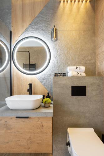 a bathroom with a white sink and a mirror at Wrota Chałubińskiego in Zakopane