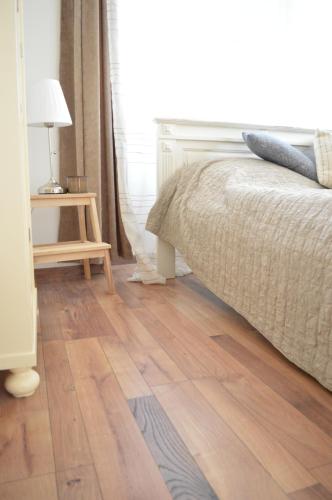 a bedroom with a bed and a wooden floor at Kiskilenc Vendégház in Szarvaskő