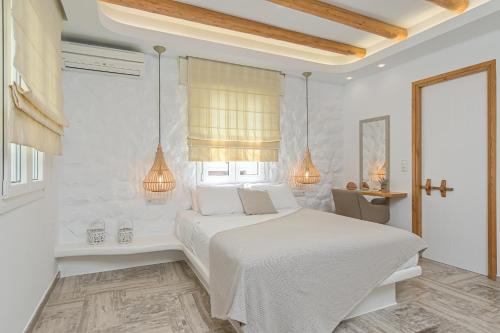 a white bedroom with a white bed and a desk at Blue Sky Summer in Naxos Chora