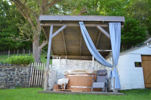 a gazebo with a table and chairs under it at Kiskilenc Vendégház in Szarvaskő