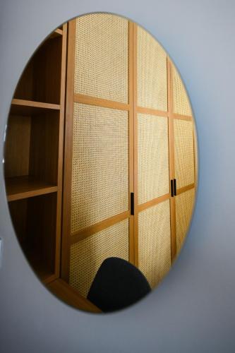 a mirror reflecting a room with a door and a chair at Eumorphia Studios & Apartments in Skiathos Town