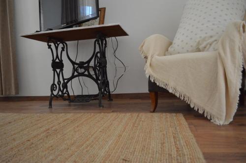 a living room with a table next to a couch at Kiskilenc Vendégház in Szarvaskő