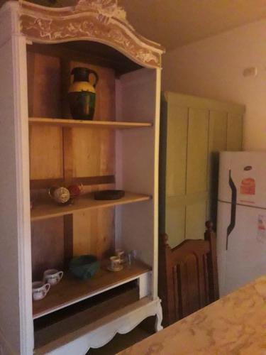 a room with a kitchen with a shelf and a refrigerator at LOFT "sencillito" a pasos de la RUTA 34 in Rafaela