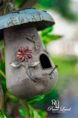 a bird feeder with a flower and two insects on it at Hotel RH Boutique Aruba in Oranjestad
