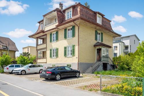 une maison avec des voitures garées devant elle dans l'établissement Erlen home, à Lucerne