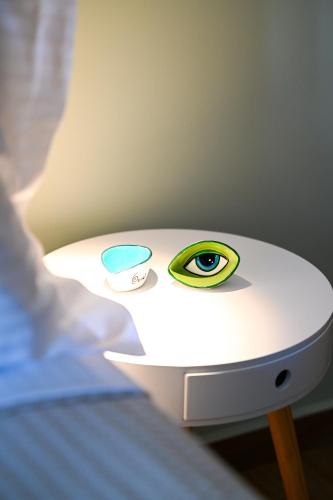 a table with an eye sitting on top of a bed at Eumorphia Studios & Apartments in Skiathos Town