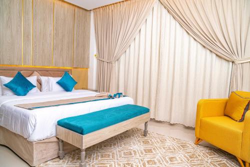 1 dormitorio con 1 cama y 1 silla amarilla en فندق الغيمة التاسعة en Hafr Al Batin