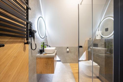 a bathroom with a toilet and a sink and a mirror at Wrota Chałubińskiego in Zakopane