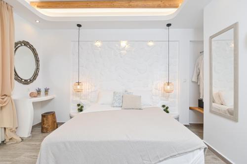 a white bedroom with a bed and a mirror at Blue Sky Summer in Naxos Chora