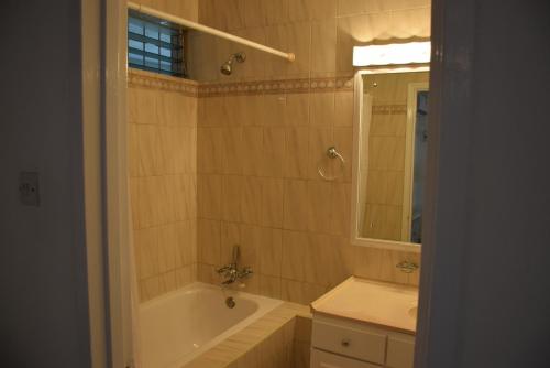a bathroom with a tub and a sink and a mirror at Goldenview in Saint James
