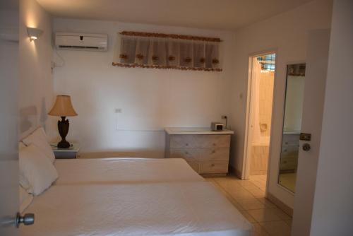 a bedroom with a large white bed and a dresser at Goldenview in Saint James