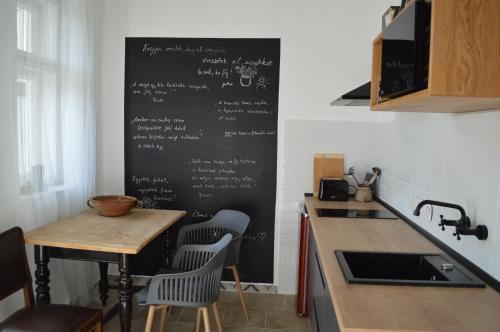 a kitchen with a black chalkboard on the wall at Kiskilenc Vendégház in Szarvaskő
