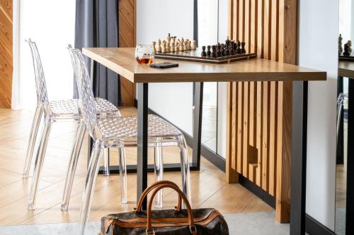 a dining room table with two chairs and a chessboard at Wrota Chałubińskiego in Zakopane