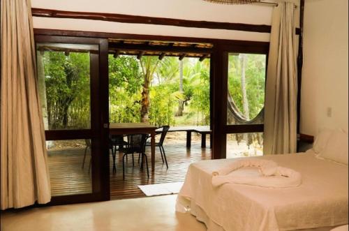 a bedroom with a bed and a view of a patio at Vivant Eco Resort apartamento in Barra Grande