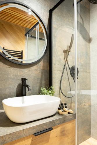 a bathroom with a sink and a mirror at Wrota Chałubińskiego in Zakopane