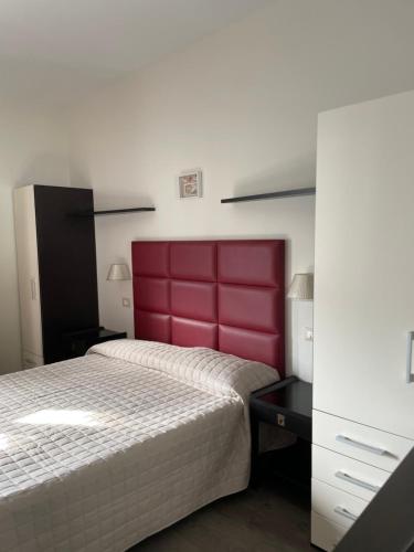 sypialnia z dużym łóżkiem z czerwonym zagłówkiem w obiekcie Hotel Vera w Cesenatico