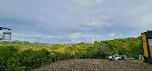 a view of a hill with a car parked in a yard at Stablo guest house in Bărăşti