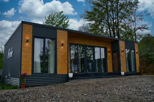 a tiny house with a black and orange exterior at Stablo guest house in Bărăşti