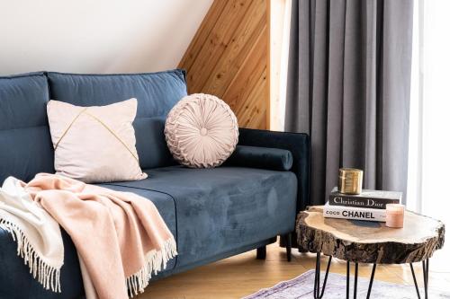 a blue couch in a living room with a table at Wrota Chałubińskiego in Zakopane