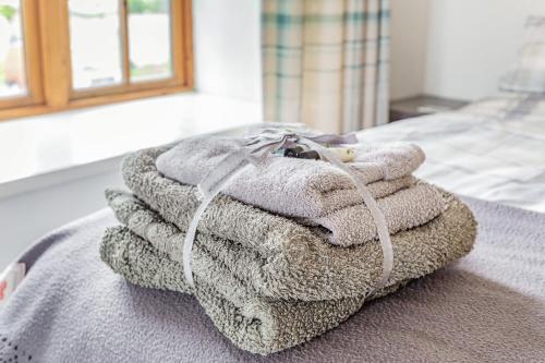 a pile of towels sitting on top of a bed at Victoria Cottage in Newquay