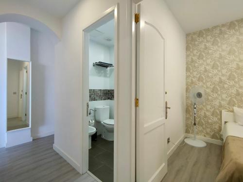 a white bathroom with a toilet and a sink at CANARIAN HOLIDAY HOME - Yumbo Luxury Apartment in Maspalomas
