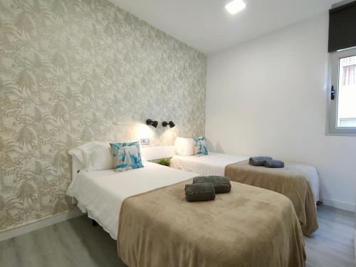 um quarto com duas camas e um sofá em CANARIAN HOLIDAY HOME - Yumbo Luxury Apartment em Maspalomas