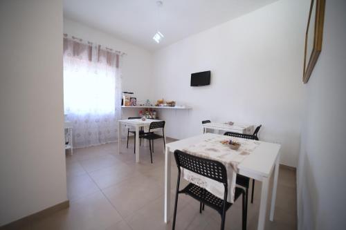 a dining room with a white table and chairs at B&B VANNEFORA in San Nicola Arcella