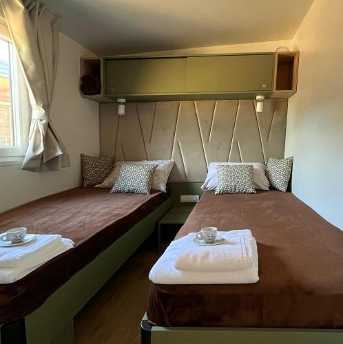 two beds sitting next to each other in a room at Mobile Home Karlo in Biograd na Moru