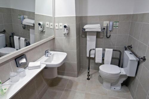 a bathroom with a toilet and a sink and a mirror at Holiday Inn Manaus by IHG in Manaus