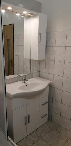 a white bathroom with a sink and a mirror at Booking Tržní in Děčín