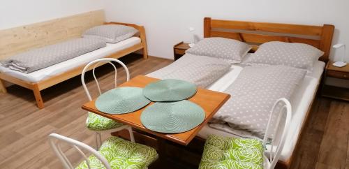 a room with two beds and a table and chairs at Booking Tržní in Děčín