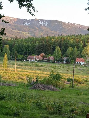 un campo con casas y una montaña en el fondo en DOMEK POD ŚMIELCEM, en Jelenia Góra-Jagniątków