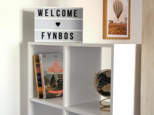 een boekenplank met boeken en een bord met fynbos als welkomstgeschenk bij Fynbos Studio DG in der Altstadt, Frauenkirchenblick, Parkplatz in Meißen